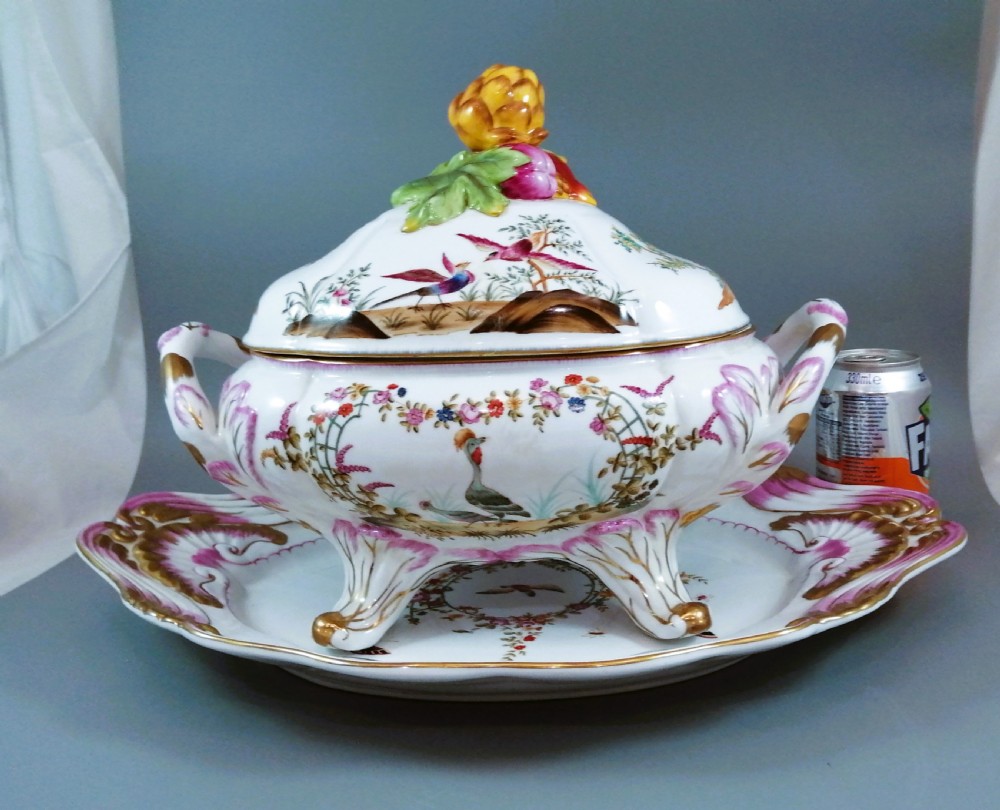An antique continental porcelain soup tureen with a fruit finial lid, dual handles, and matching underplate, decorated with hand-painted birds and gilded scrollwork. View XVII