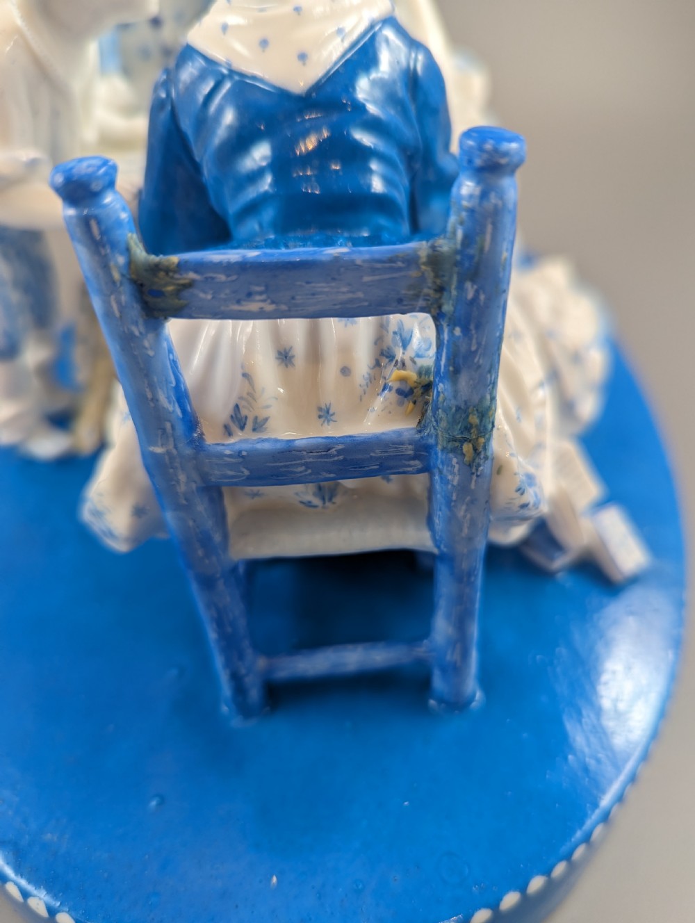 Late 19th-century French blue and white glazed porcelain figurine group depicting four figures gathered around a table fortune-telling on an oval blue base. View X