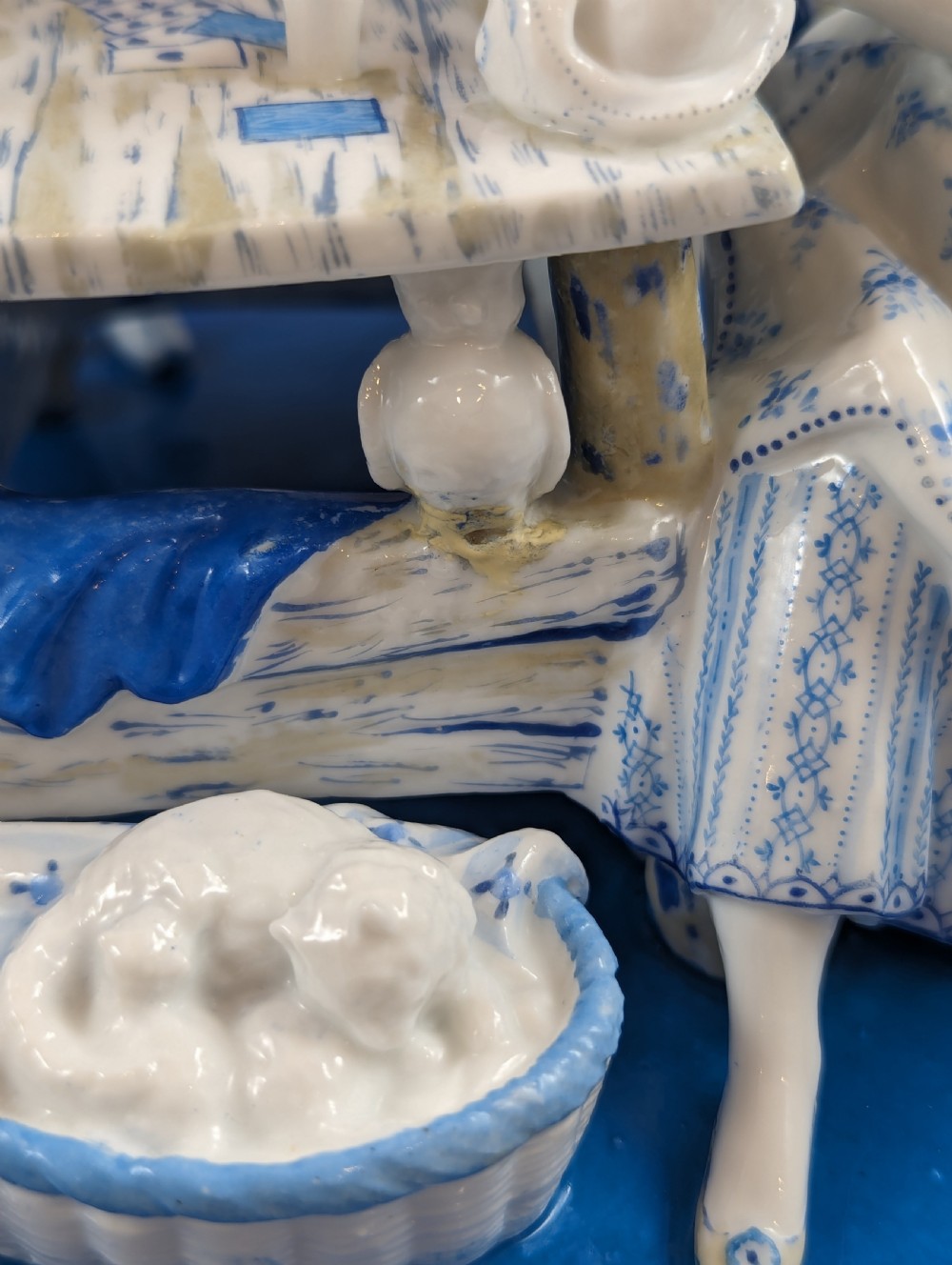 Late 19th-century French blue and white glazed porcelain figurine group depicting four figures gathered around a table fortune-telling on an oval blue base. View XII
