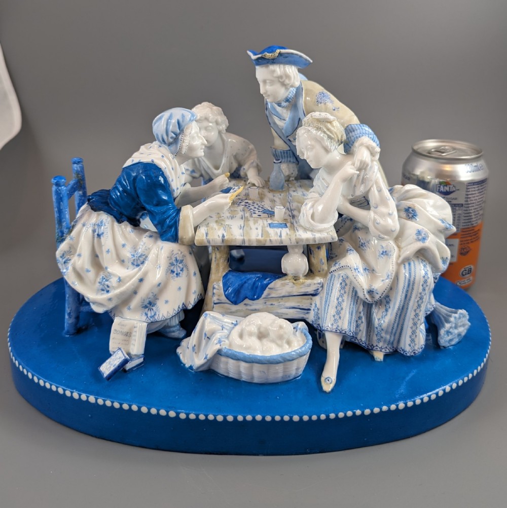 Late 19th-century French blue and white glazed porcelain figurine group depicting four figures gathered around a table fortune-telling on an oval blue base. View XV