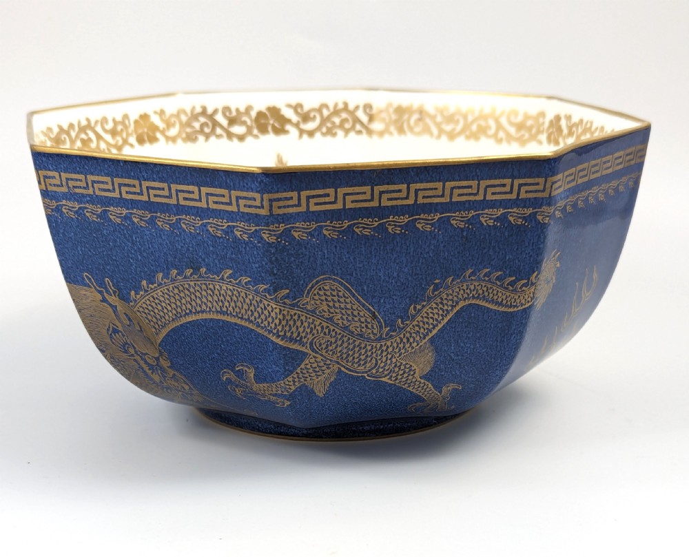 An octagonal cobalt blue ceramic bowl featuring gilded celestial dragon motifs and a Greek key upper rim. View II