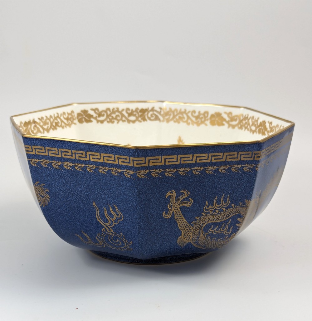 An octagonal cobalt blue ceramic bowl featuring gilded celestial dragon motifs and a Greek key upper rim. View VIII