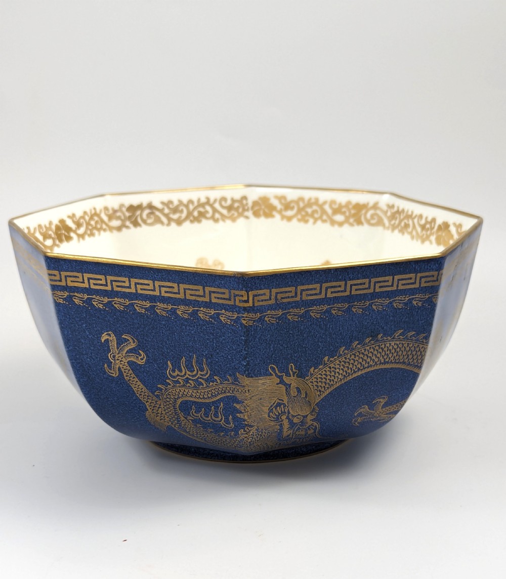 An octagonal cobalt blue ceramic bowl featuring gilded celestial dragon motifs and a Greek key upper rim. View IX