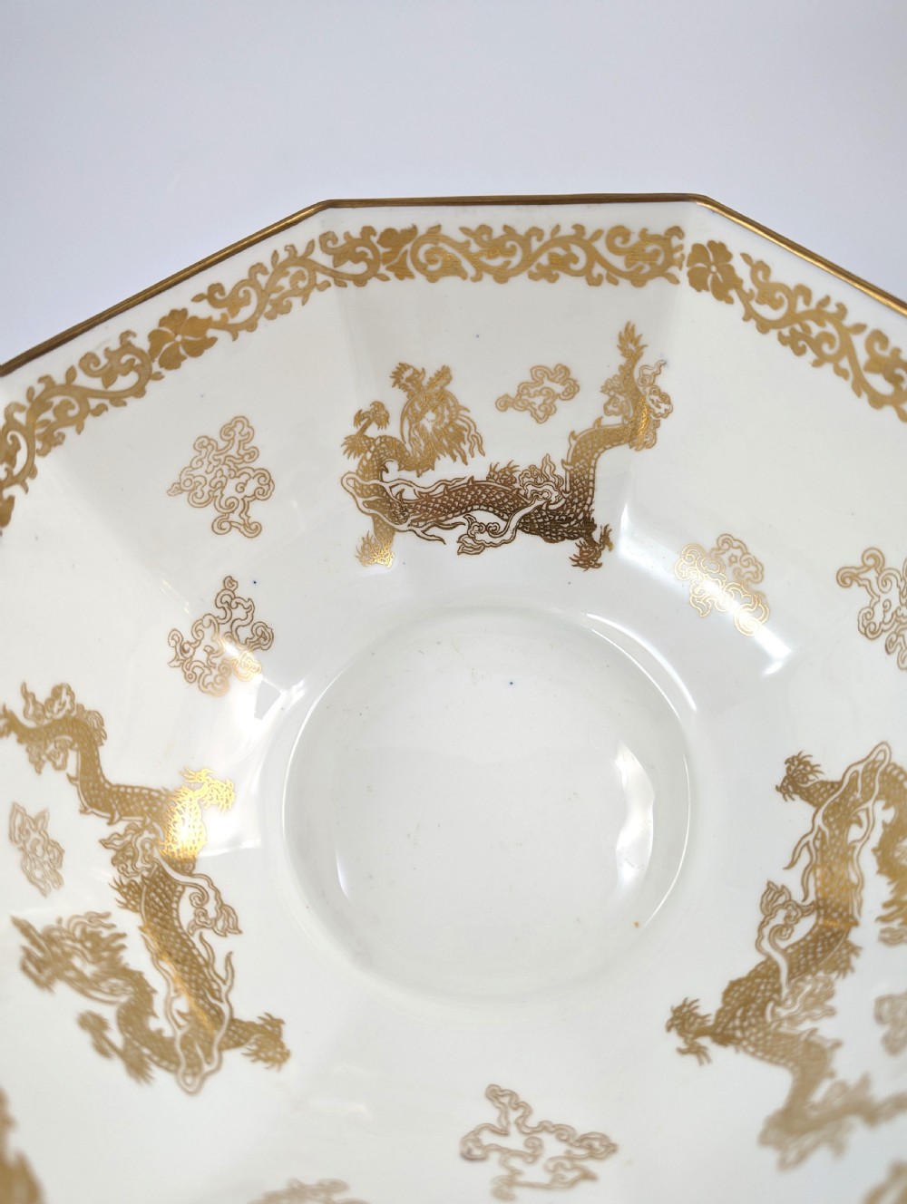 An octagonal cobalt blue ceramic bowl featuring gilded celestial dragon motifs and a Greek key upper rim. View XI