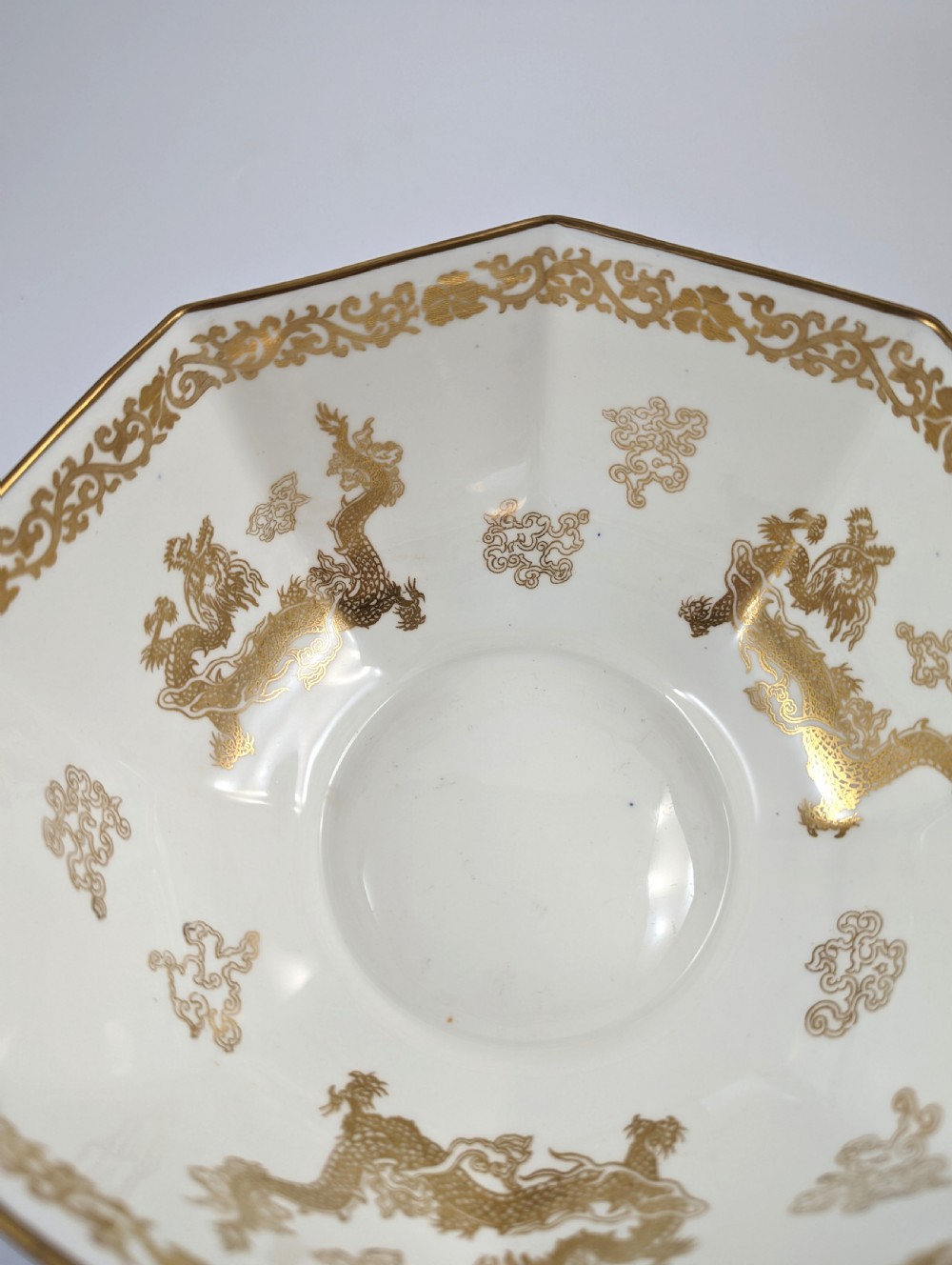 An octagonal cobalt blue ceramic bowl featuring gilded celestial dragon motifs and a Greek key upper rim. View XII