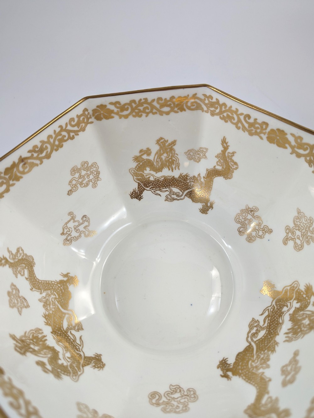 An octagonal cobalt blue ceramic bowl featuring gilded celestial dragon motifs and a Greek key upper rim. View XIII