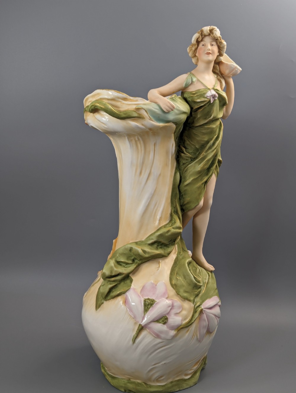 An Art Nouveau Royal Dux porcelain vase depicting a draped water nymph holding a seashell against flowing foliage in cream, olive green, and soft pink shades. View VII