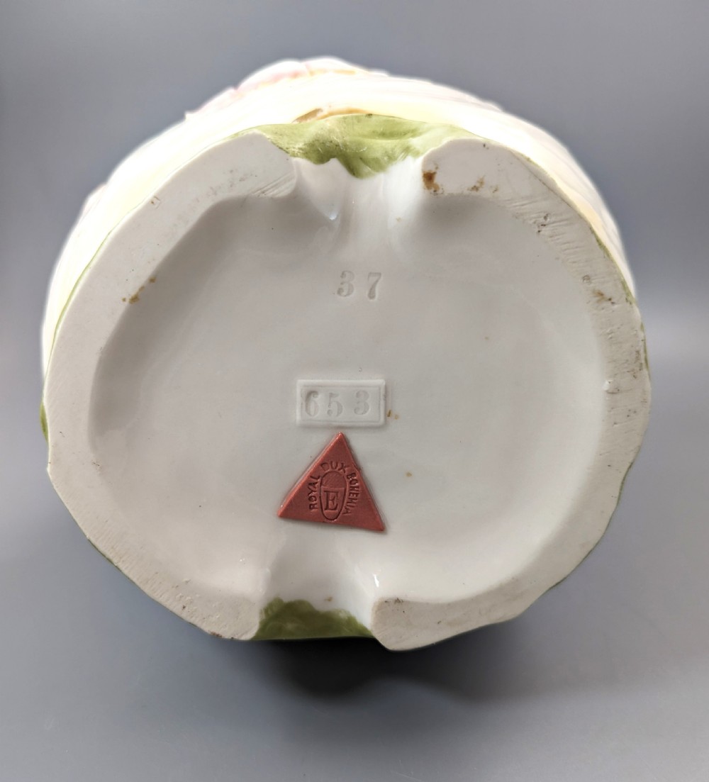 An Art Nouveau Royal Dux porcelain vase depicting a draped water nymph holding a seashell against flowing foliage in cream, olive green, and soft pink shades. View VIII
