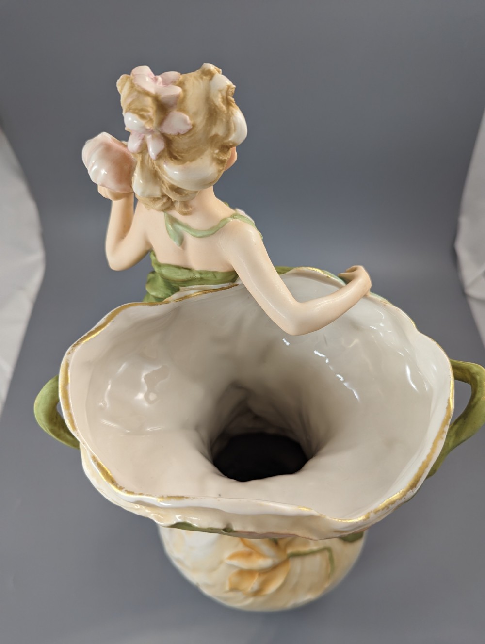 An Art Nouveau Royal Dux porcelain vase depicting a draped water nymph holding a seashell against flowing foliage in cream, olive green, and soft pink shades. View IX