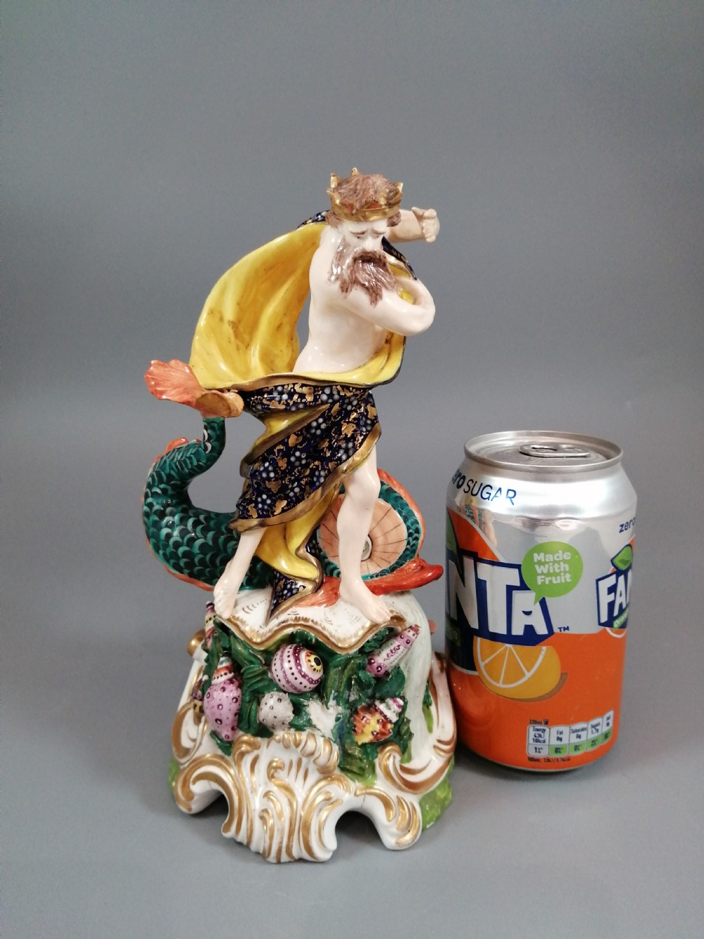 A Bloor Derby porcelain figure of Neptune standing atop a shell and rockwork base with sea creatures, wearing a crown and drapery decorated in gold leaf and blue enamel. View XIV