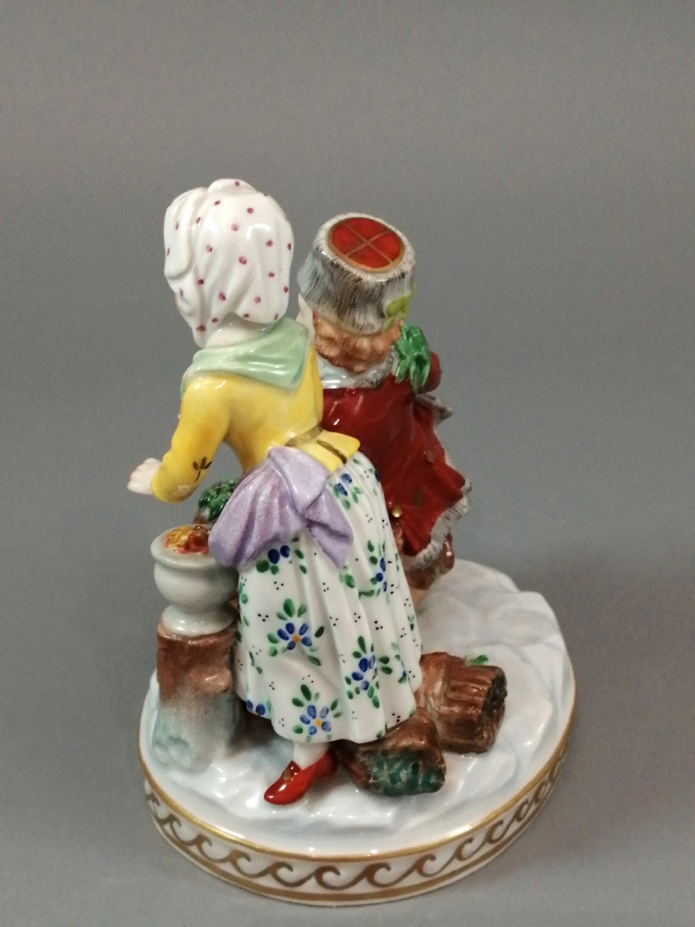 A Carl Thieme Potschappel hand-painted porcelain figurine depicting a young couple in eighteenth-century winter costume beside a sledge and brazier. View III