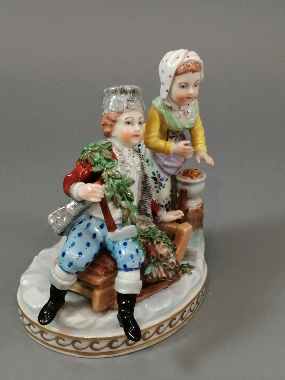 A Carl Thieme Potschappel hand-painted porcelain figurine depicting a young couple in eighteenth-century winter costume beside a sledge and brazier. View VII