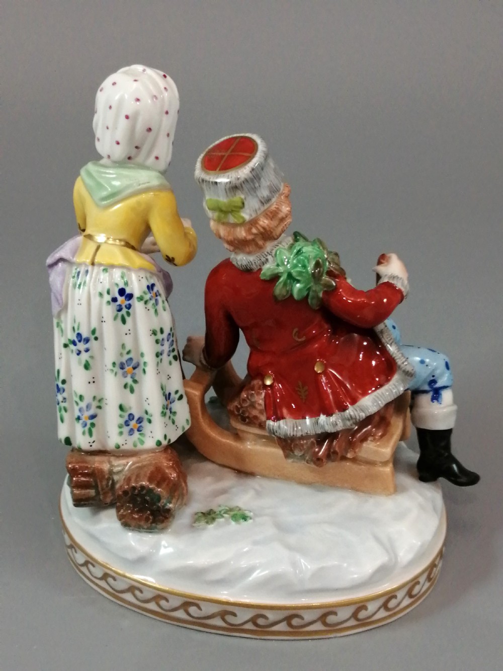 A Carl Thieme Potschappel hand-painted porcelain figurine depicting a young couple in eighteenth-century winter costume beside a sledge and brazier. View IX