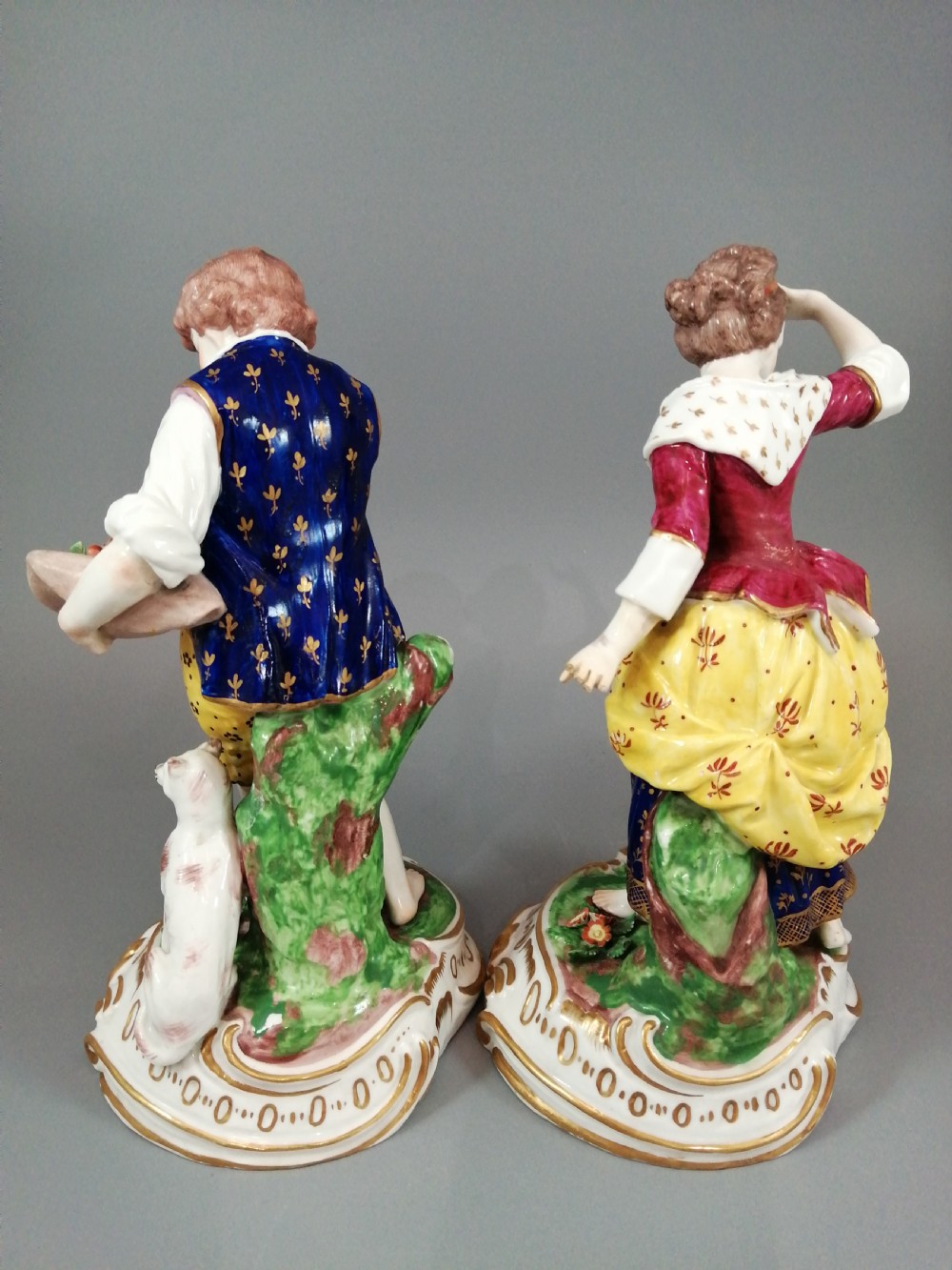 A pair of 19th-century French Samson porcelain figurines depicting a young boy with a basket of fruit and a dog alongside a shepherdess with a lamb, decorated with polychrome enamels and gilded scroll bases. View III