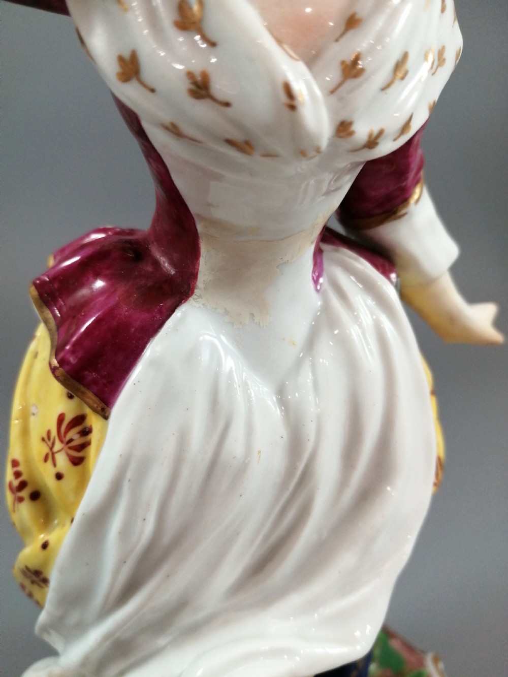 A pair of 19th-century French Samson porcelain figurines depicting a young boy with a basket of fruit and a dog alongside a shepherdess with a lamb, decorated with polychrome enamels and gilded scroll bases. View IX
