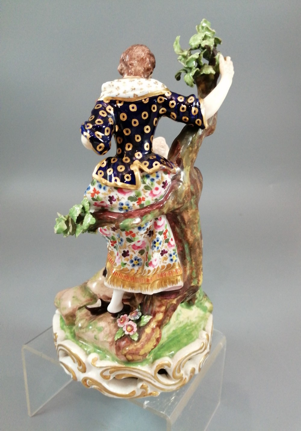 Early 19th-century Derby porcelain figural group depicting a shoemaker and a standing lady beside a tree on a gilded scroll base. View III