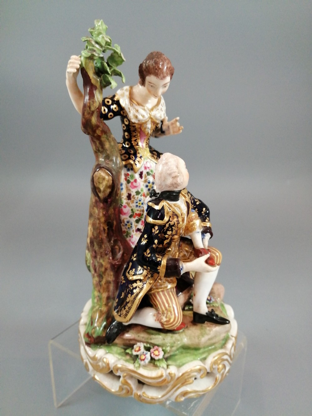 Early 19th-century Derby porcelain figural group depicting a shoemaker and a standing lady beside a tree on a gilded scroll base. View V