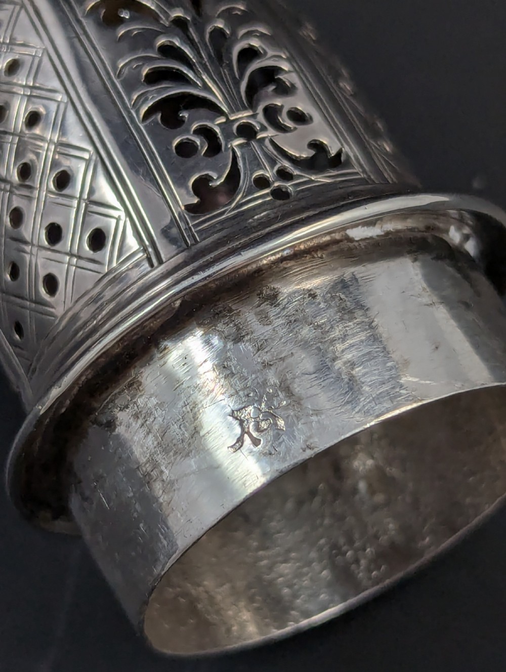 A pair of George II sterling silver baluster-form casters featuring pierced lattice tops, chased scroll detailing, and stepped pedestal bases. View IX