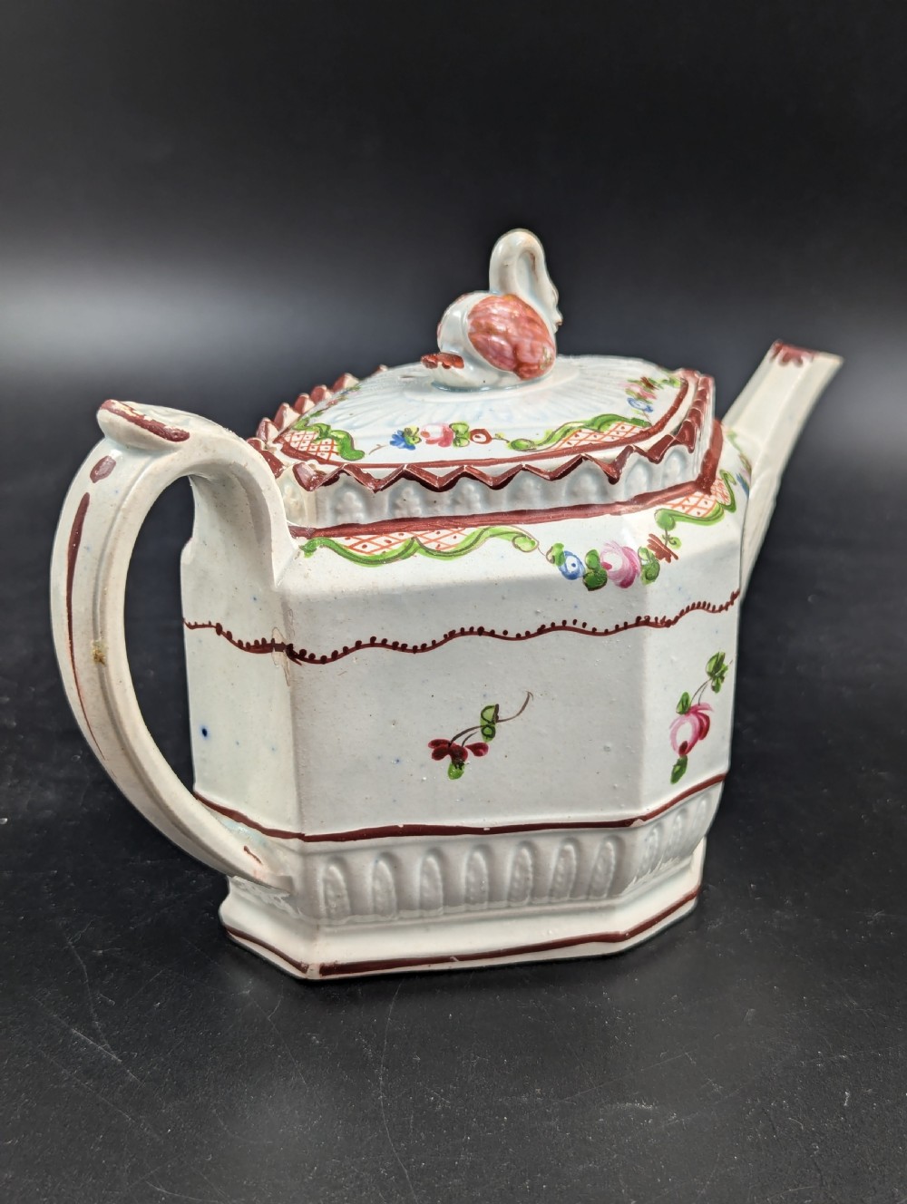 An octagonal off-white antique pearlware teapot decorated with hand-painted floral sprigs, a fluted base, and a swan-form lid knop. View III