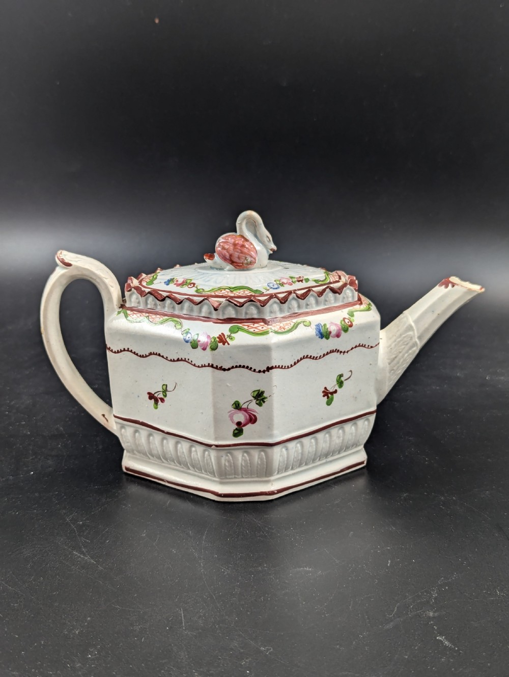 An octagonal off-white antique pearlware teapot decorated with hand-painted floral sprigs, a fluted base, and a swan-form lid knop. View IV