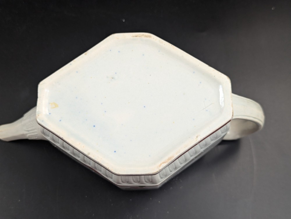 An octagonal off-white antique pearlware teapot decorated with hand-painted floral sprigs, a fluted base, and a swan-form lid knop. View VI