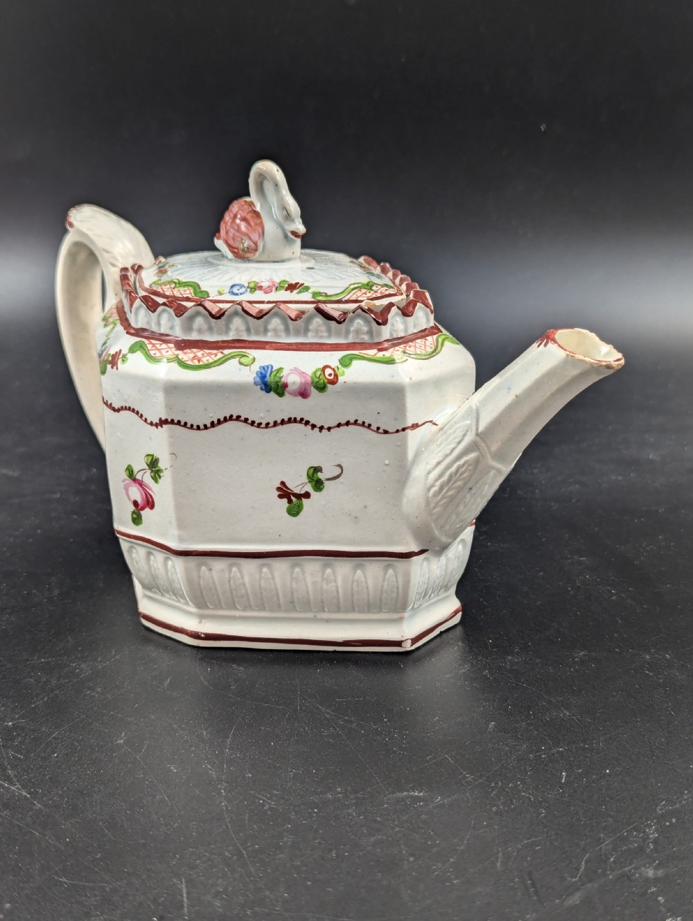 An octagonal off-white antique pearlware teapot decorated with hand-painted floral sprigs, a fluted base, and a swan-form lid knop. View XI