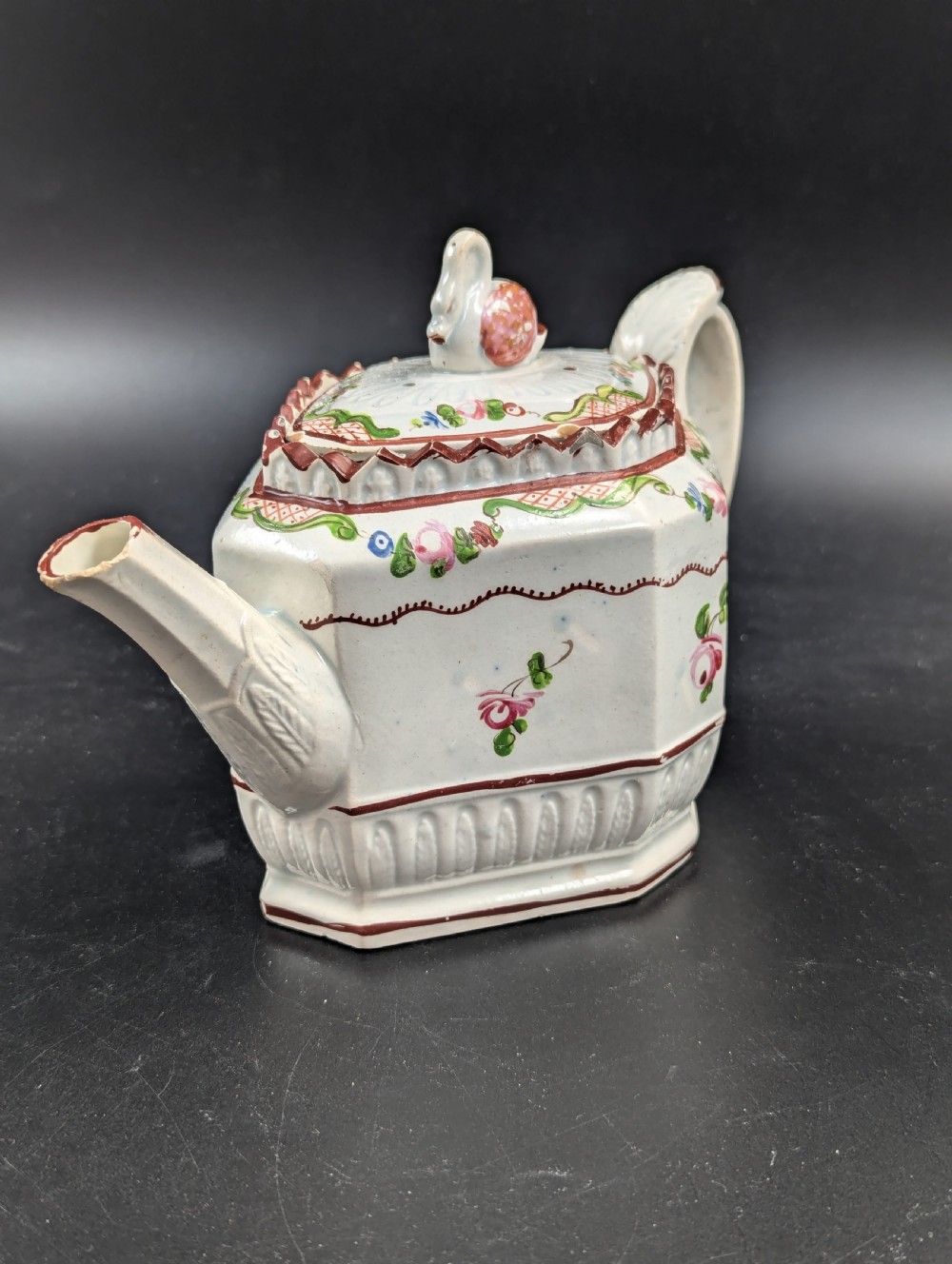 An octagonal off-white antique pearlware teapot decorated with hand-painted floral sprigs, a fluted base, and a swan-form lid knop. View XII