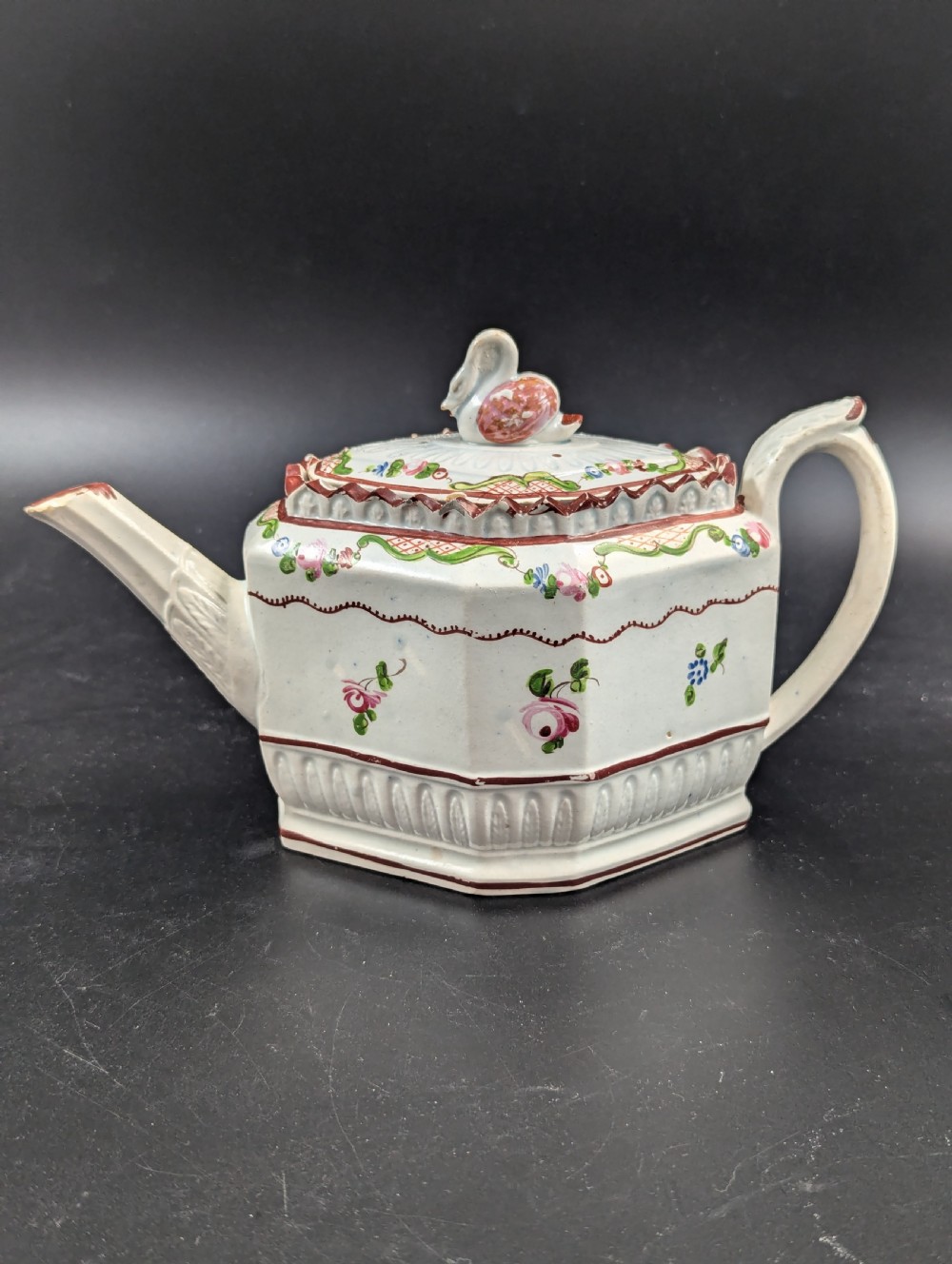 An octagonal off-white antique pearlware teapot decorated with hand-painted floral sprigs, a fluted base, and a swan-form lid knop. View XIII