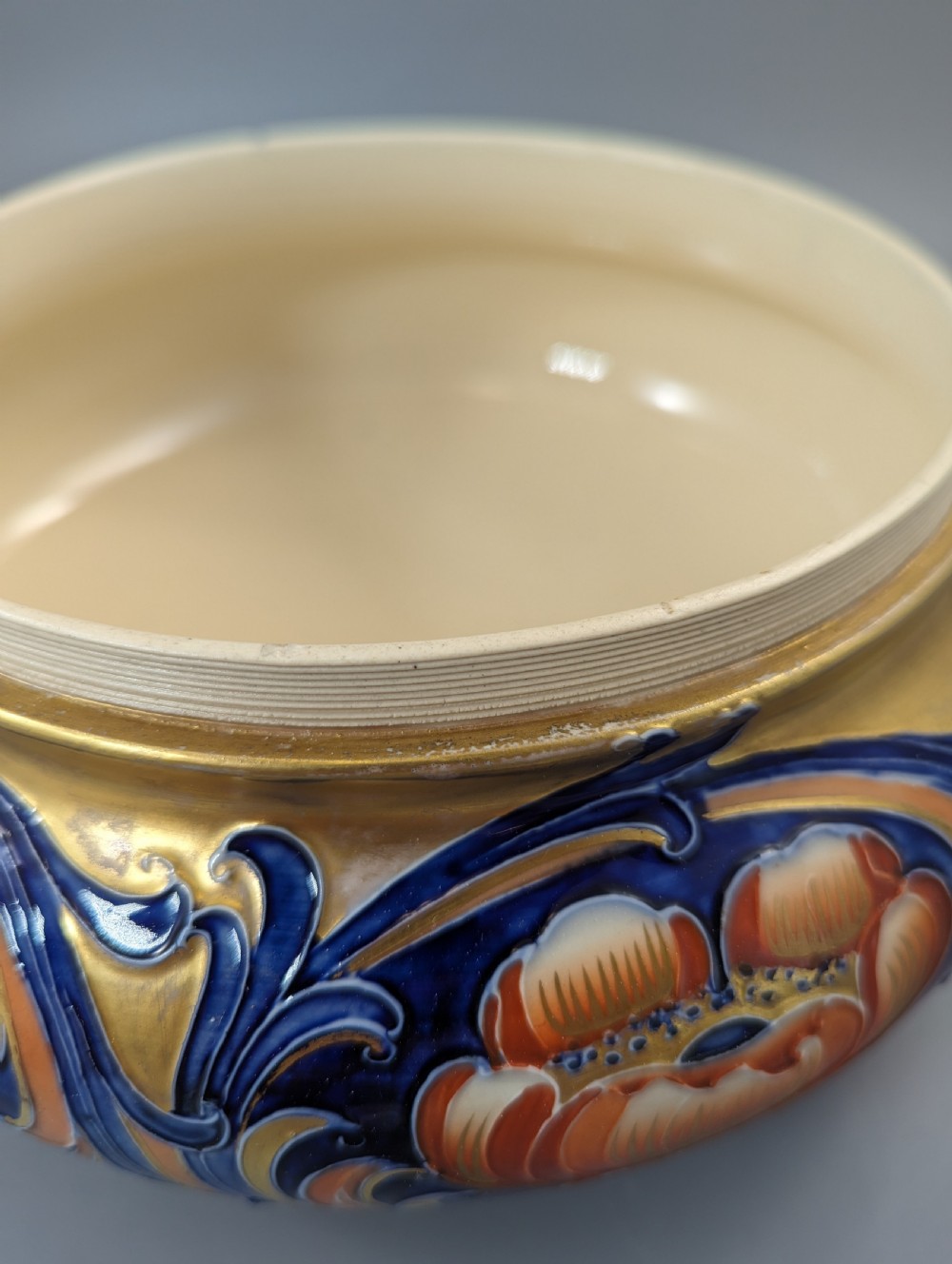 An Edwardian Moorcroft Macintyre ceramic pot pourri jar with a pierced lid, featuring hand-painted tube-lined floral decoration in cobalt blue, coral, and gold. View VII