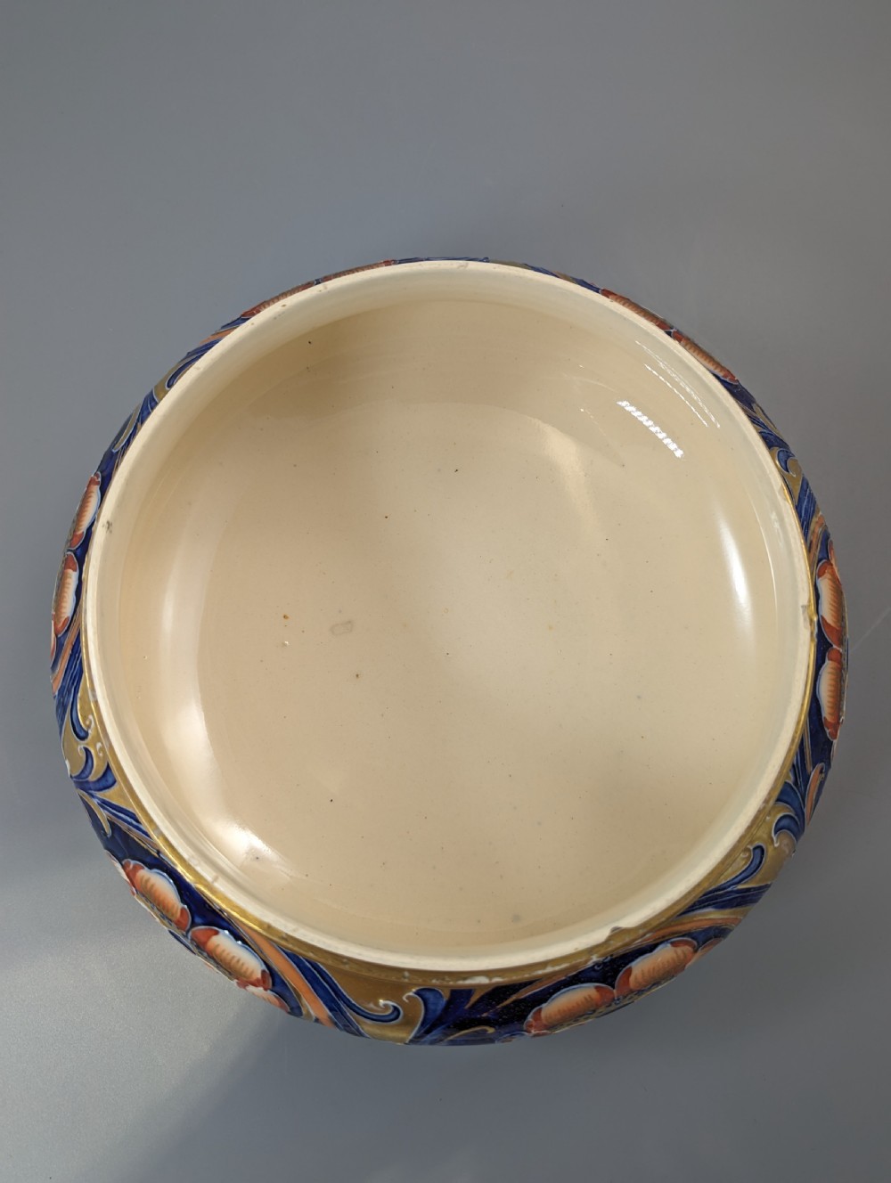 An Edwardian Moorcroft Macintyre ceramic pot pourri jar with a pierced lid, featuring hand-painted tube-lined floral decoration in cobalt blue, coral, and gold. View IX