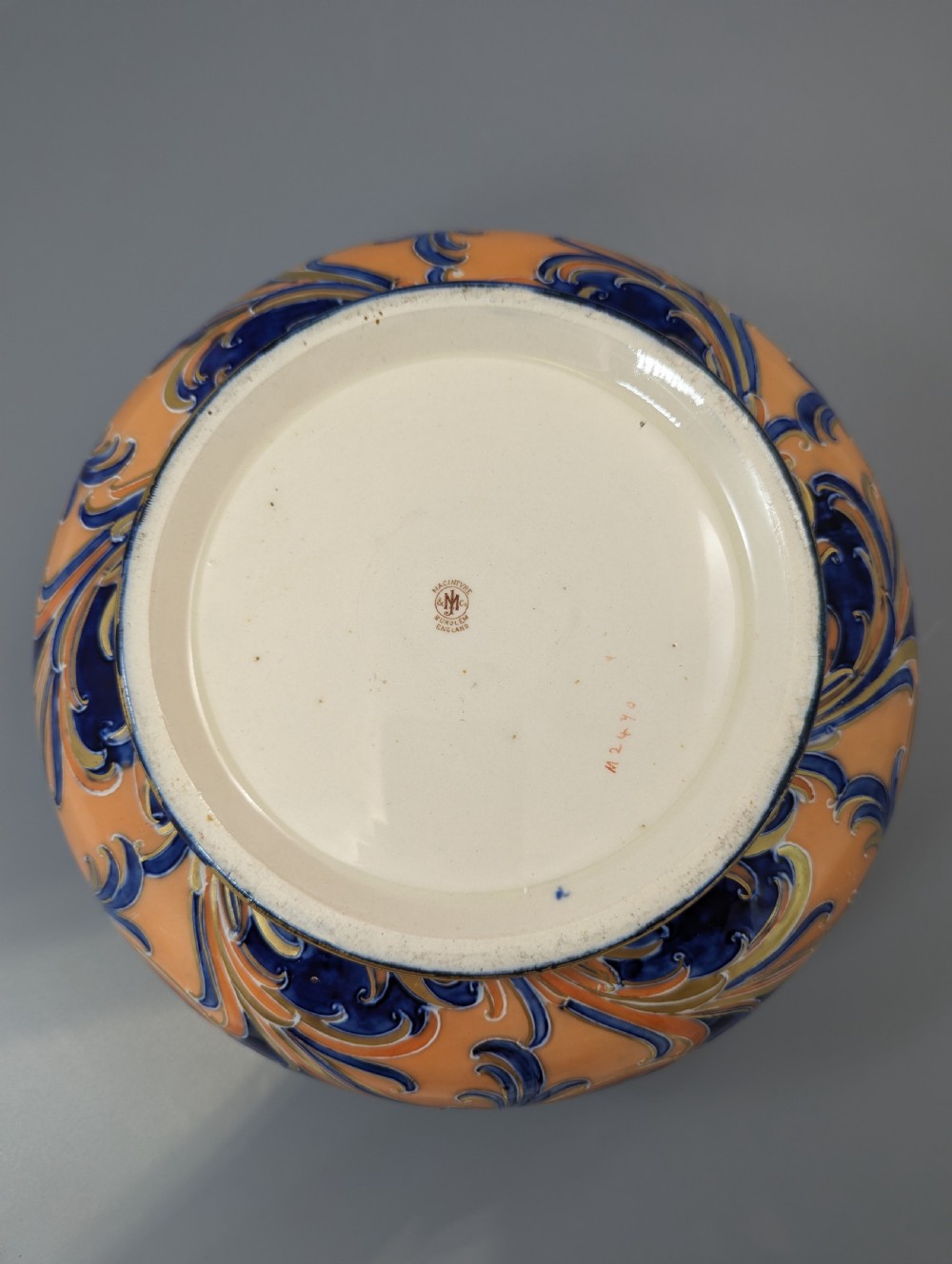 An Edwardian Moorcroft Macintyre ceramic pot pourri jar with a pierced lid, featuring hand-painted tube-lined floral decoration in cobalt blue, coral, and gold. View X