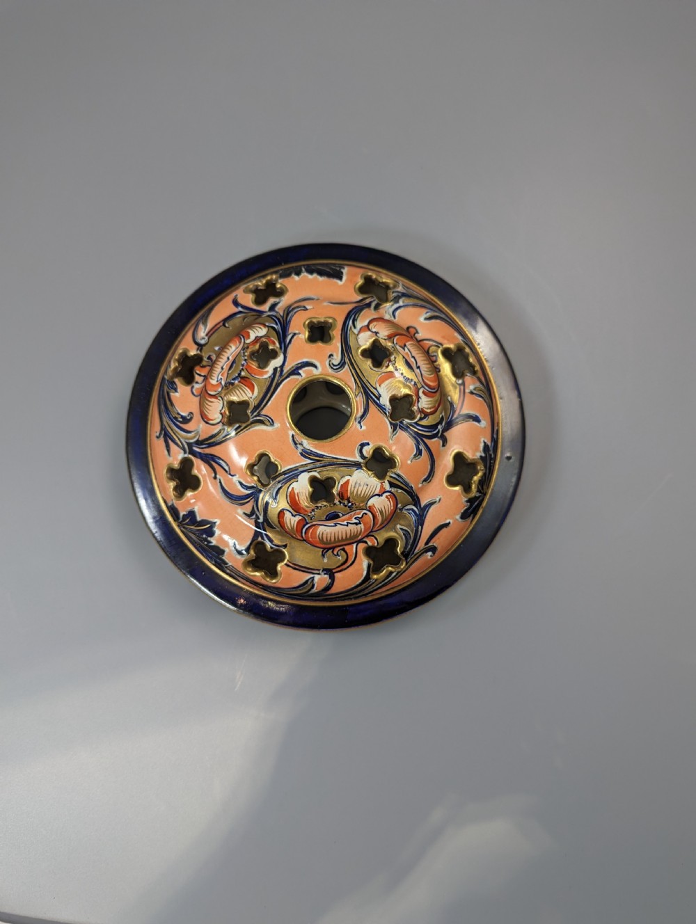 An Edwardian Moorcroft Macintyre ceramic pot pourri jar with a pierced lid, featuring hand-painted tube-lined floral decoration in cobalt blue, coral, and gold. View XIV