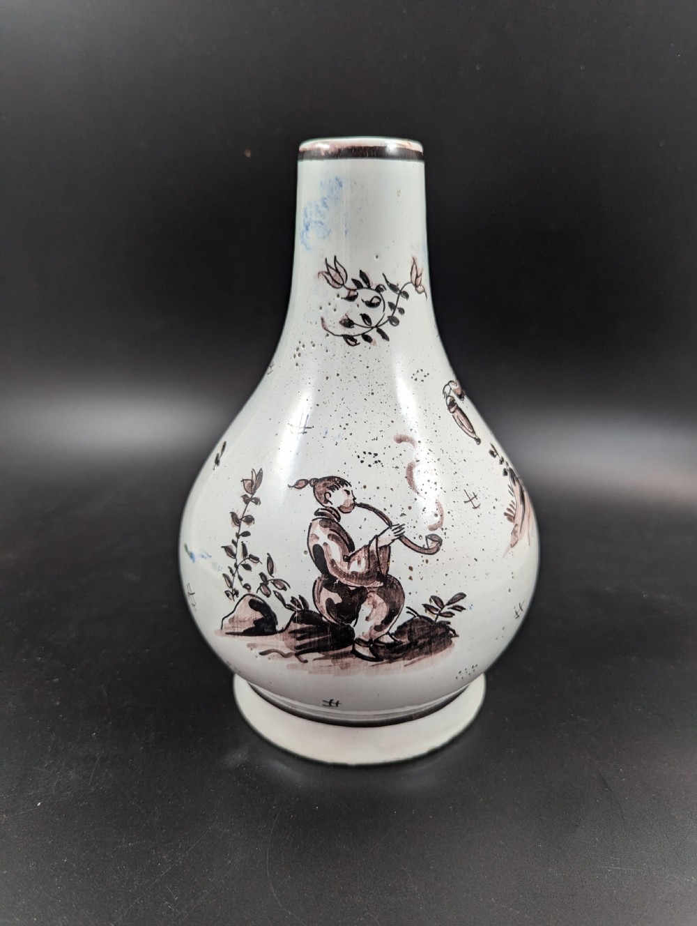 A mid-18th-century tin-glazed earthenware vase with a pear-shaped body, decorated with hand-painted manganese Chinoiserie figures.
