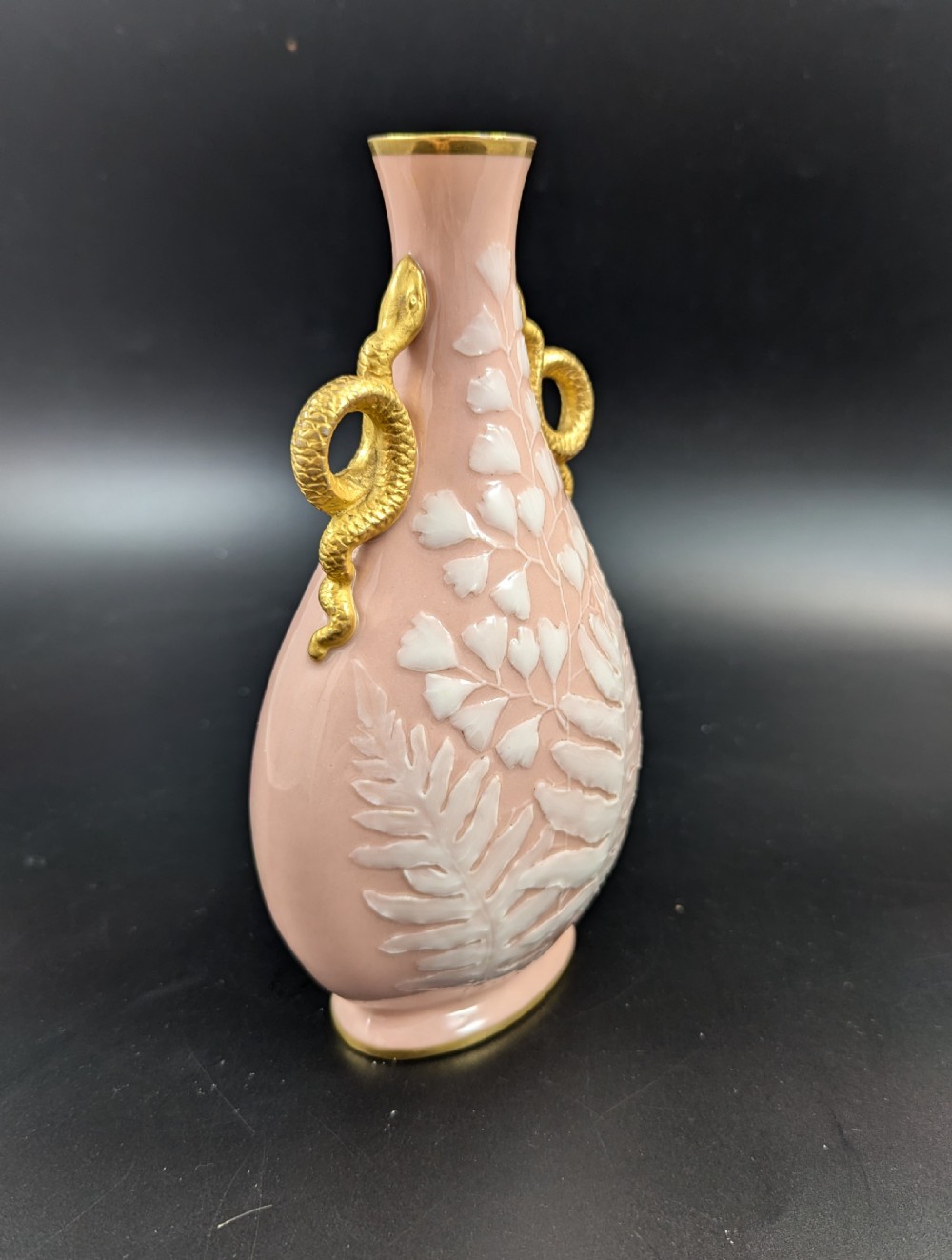 A blush pink porcelain vase featuring white pate-sur-pate fern foliage decoration and two gilded serpent handles. View V