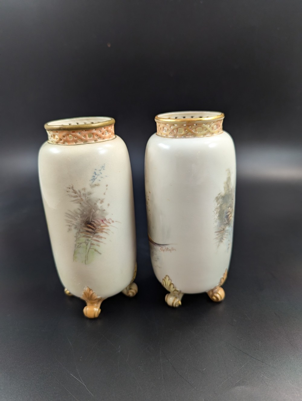 A pair of Edwardian Royal Worcester porcelain vases featuring hand-painted pheasants in natural landscapes, with reticulated rims and gilt scroll feet. View III