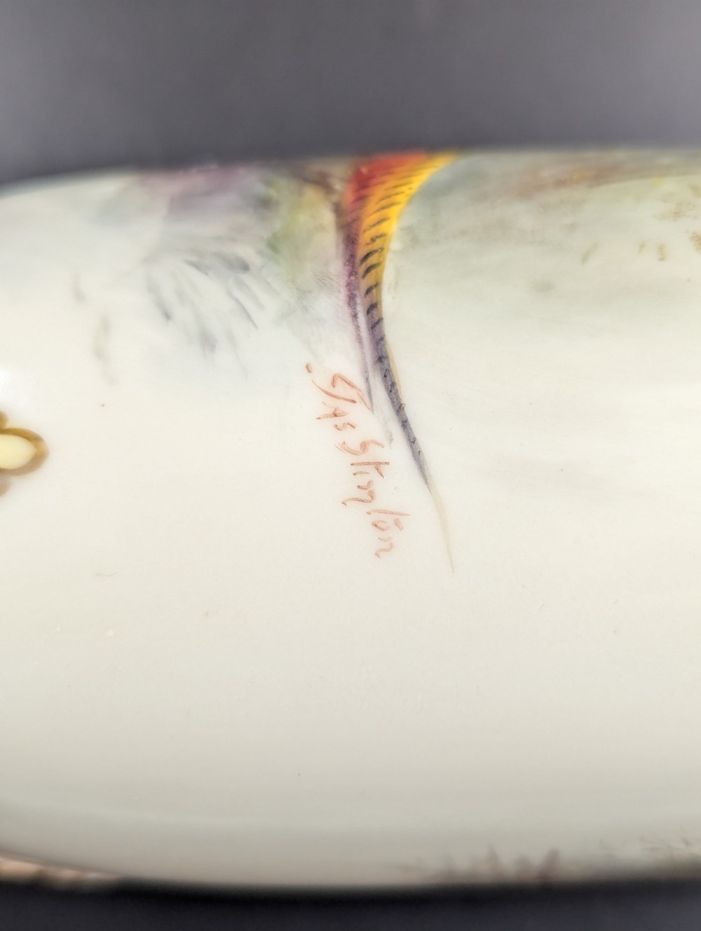 A pair of Edwardian Royal Worcester porcelain vases featuring hand-painted pheasants in natural landscapes, with reticulated rims and gilt scroll feet. View XII