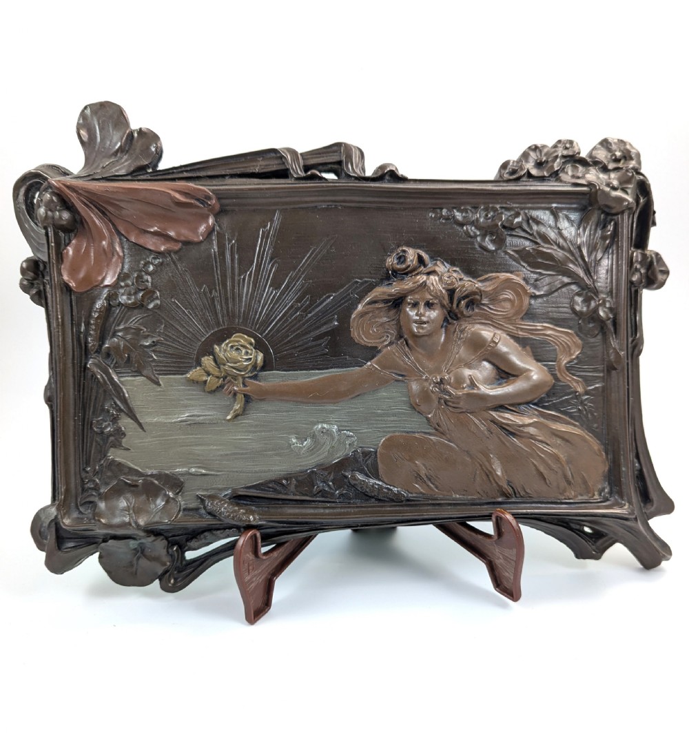 A rectangular French Art Nouveau terracotta relief featuring a draped female figure holding a rose against a rising sun background with a metallic finish. View II