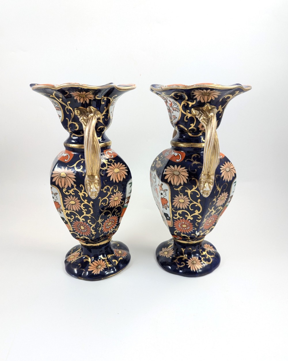 A pair of antique Masons ironstone vases decorated in a cobalt blue and terracotta Imari pattern with double gilt handles. View II