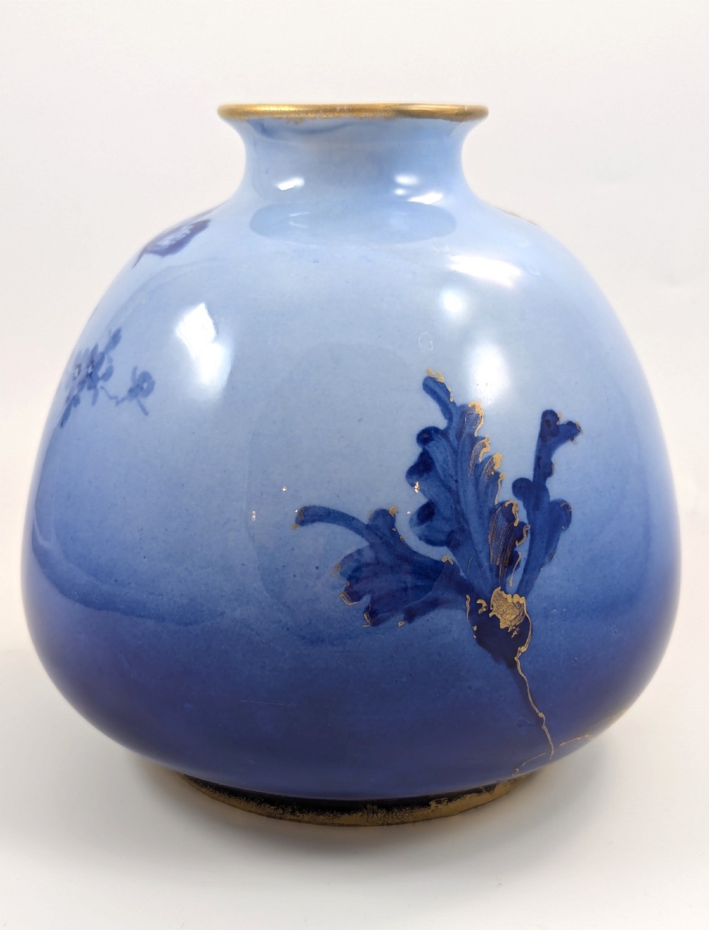 A bulbous Art Nouveau porcelain vase featuring a blue gradient backdrop decorated with hand-painted white chrysanthemums and gold gilt highlights. View III