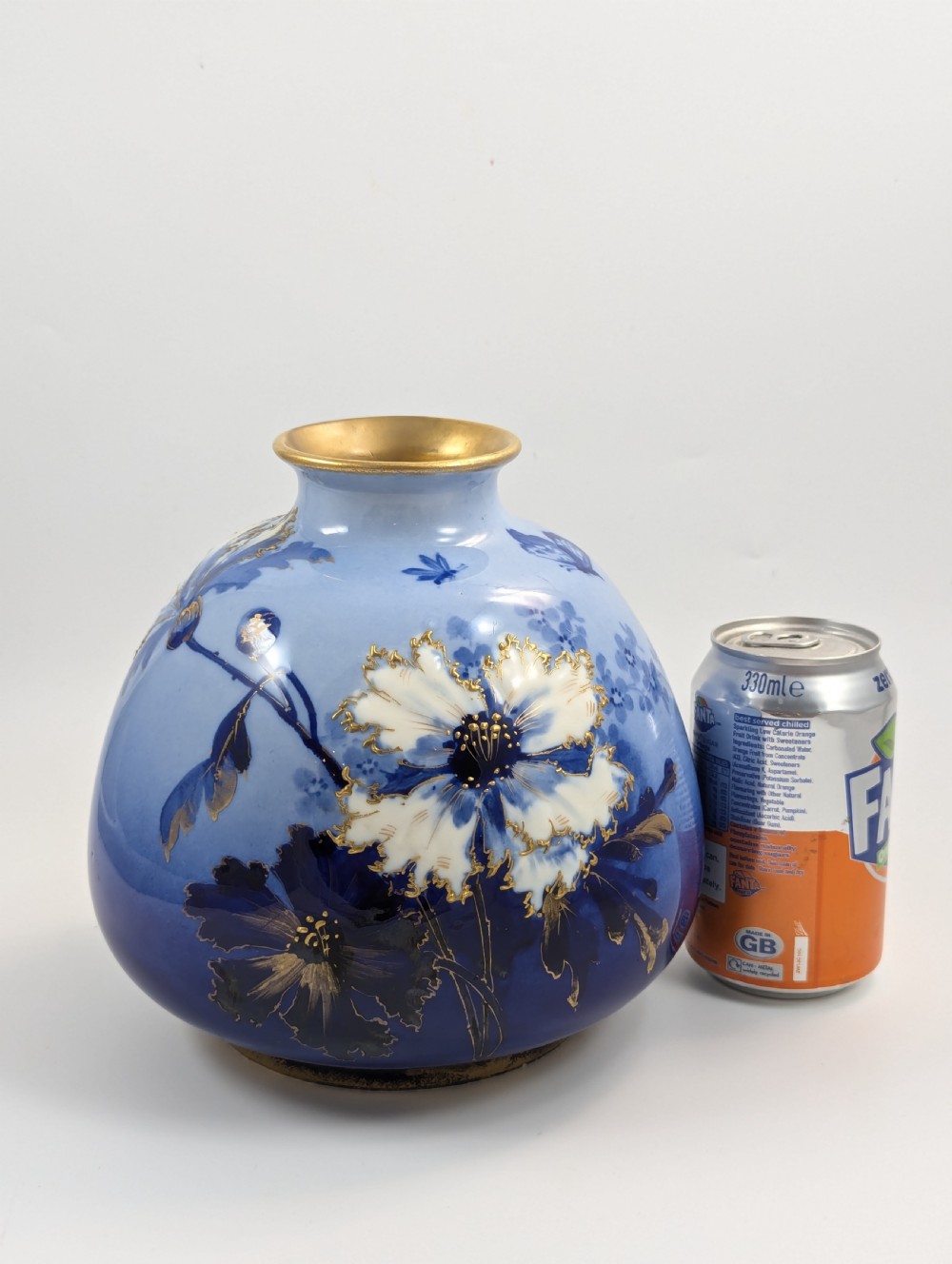 A bulbous Art Nouveau porcelain vase featuring a blue gradient backdrop decorated with hand-painted white chrysanthemums and gold gilt highlights. View VI