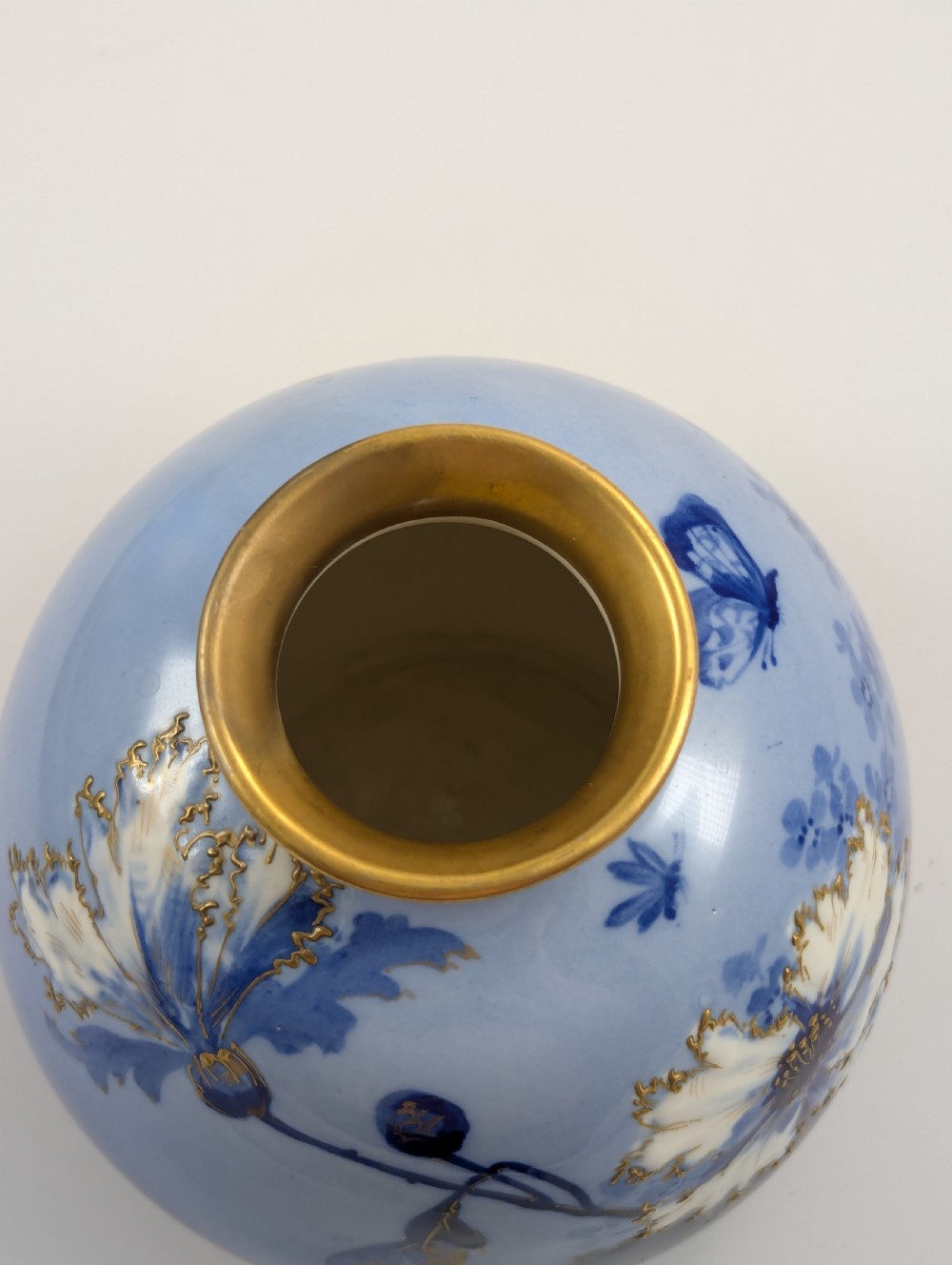 A bulbous Art Nouveau porcelain vase featuring a blue gradient backdrop decorated with hand-painted white chrysanthemums and gold gilt highlights. View VII