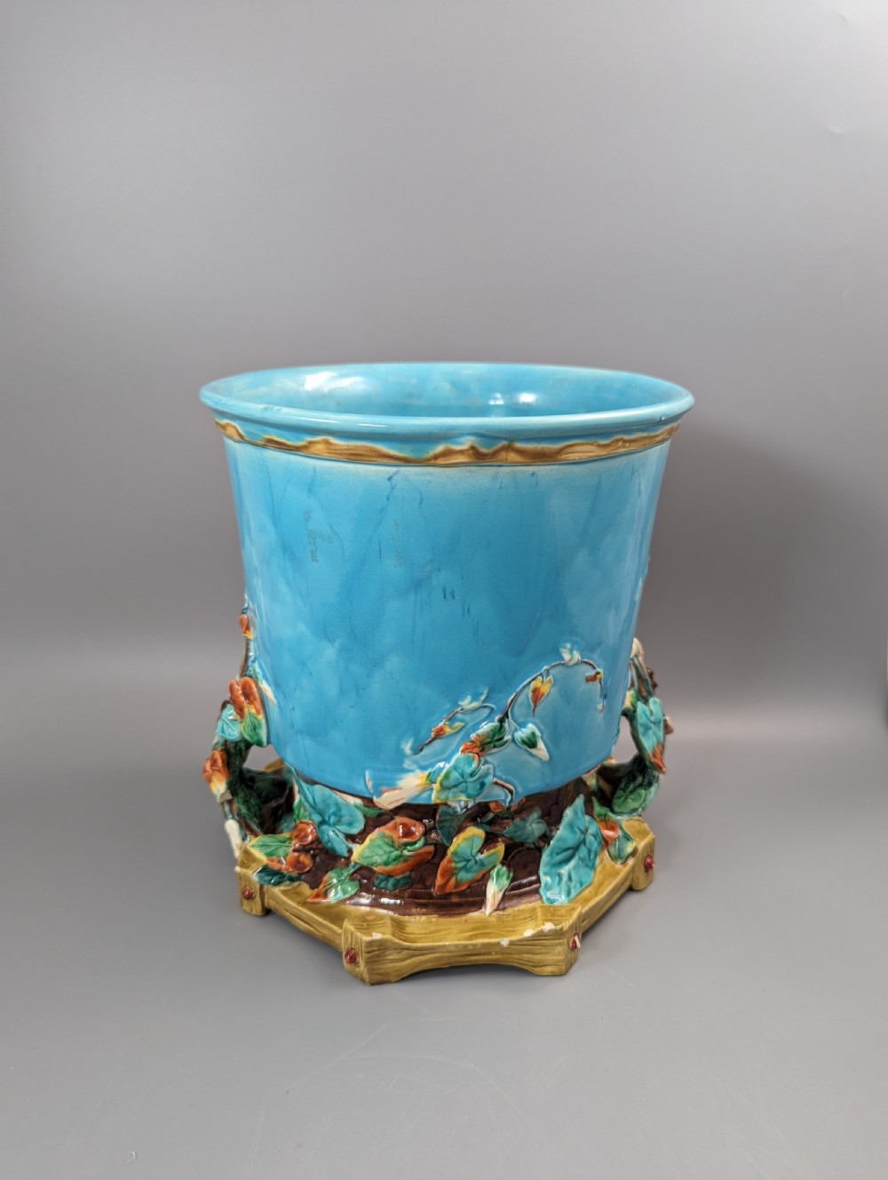 A Victorian Royal Worcester turquoise majolica jardiniere planter featuring relief-moulded foliage and a faux-woodland base. View III