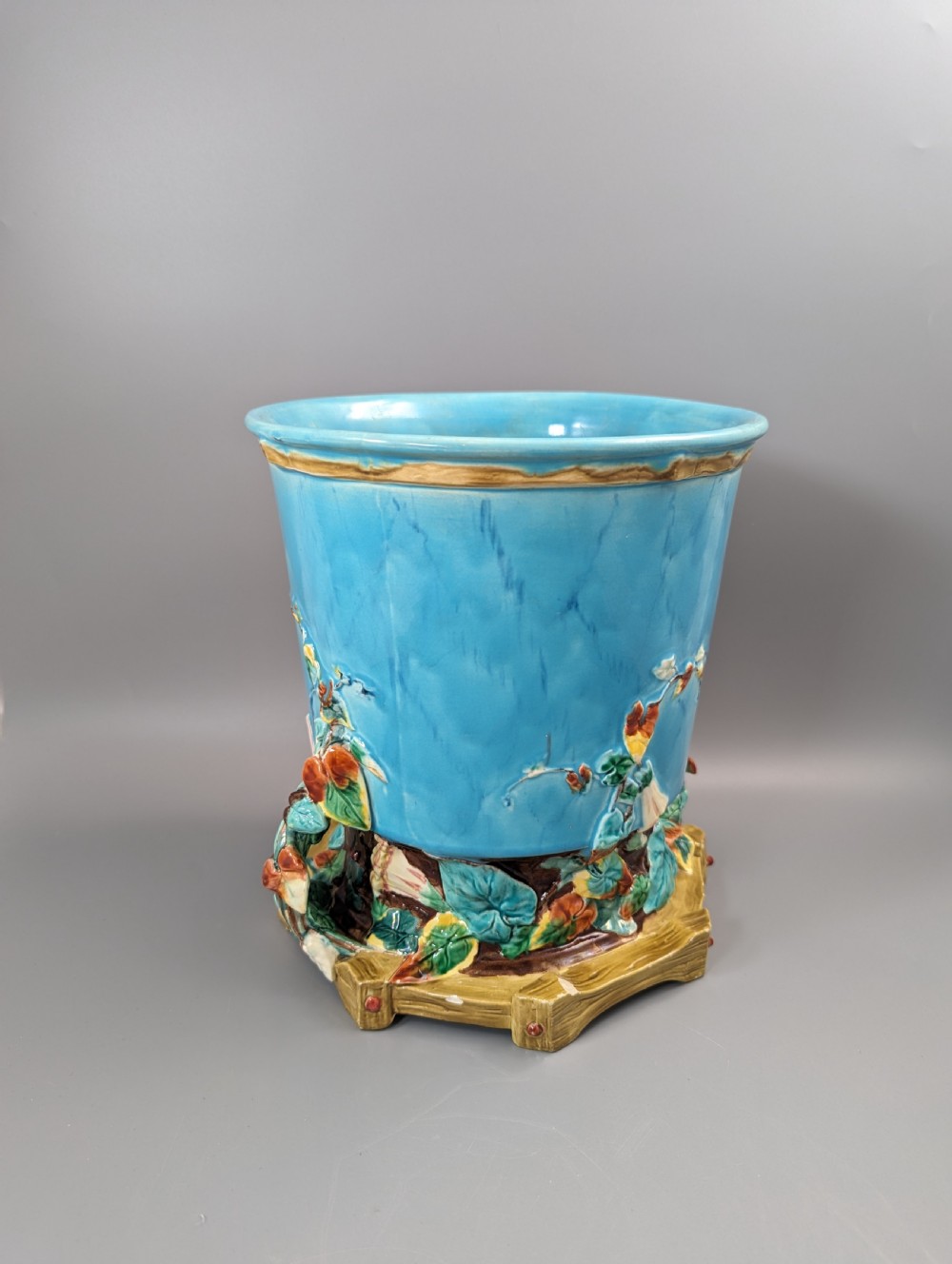 A Victorian Royal Worcester turquoise majolica jardiniere planter featuring relief-moulded foliage and a faux-woodland base. View IX