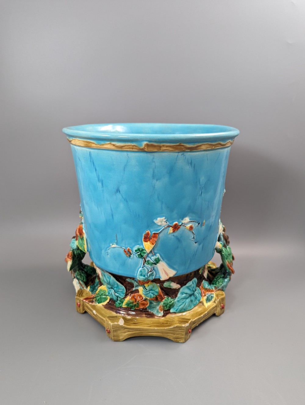 A Victorian Royal Worcester turquoise majolica jardiniere planter featuring relief-moulded foliage and a faux-woodland base. View X