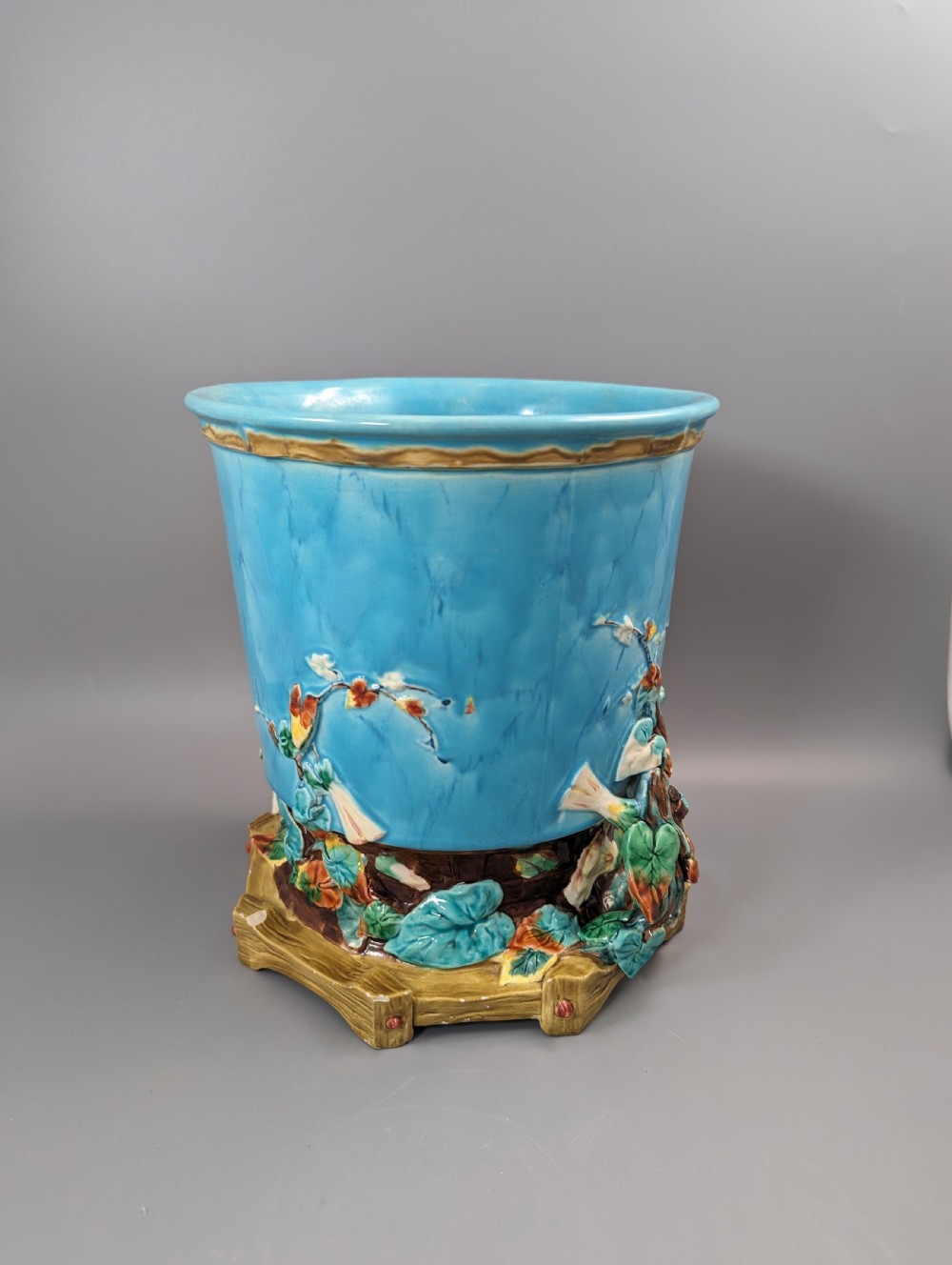 A Victorian Royal Worcester turquoise majolica jardiniere planter featuring relief-moulded foliage and a faux-woodland base. View XI
