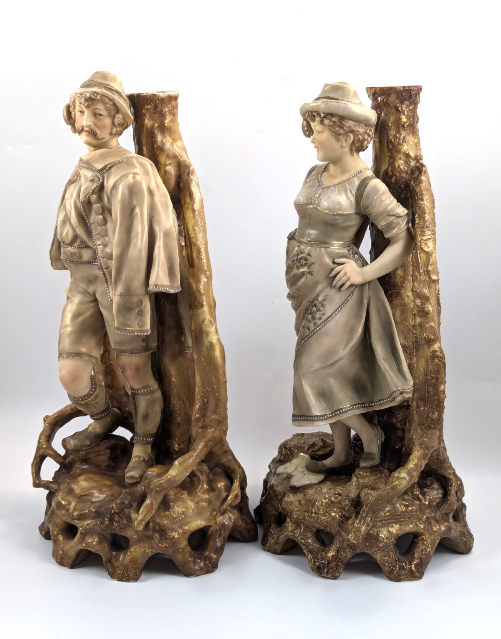 A pair of nineteenth-century Bohemian porcelain figurines depicting a man and woman in folk attire framed by gilded root-like arbours on sculpted bases. View II