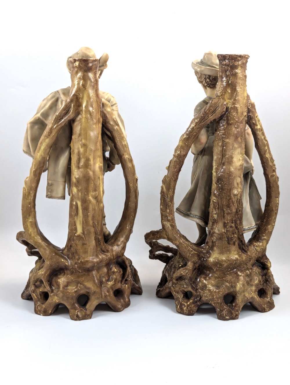 A pair of nineteenth-century Bohemian porcelain figurines depicting a man and woman in folk attire framed by gilded root-like arbours on sculpted bases. View III