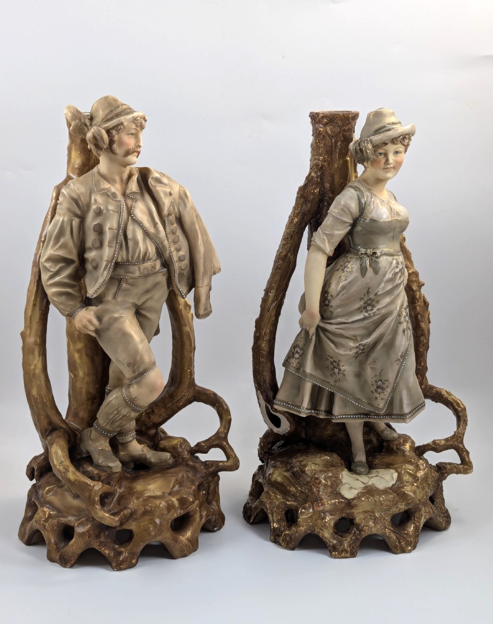 A pair of nineteenth-century Bohemian porcelain figurines depicting a man and woman in folk attire framed by gilded root-like arbours on sculpted bases. View V
