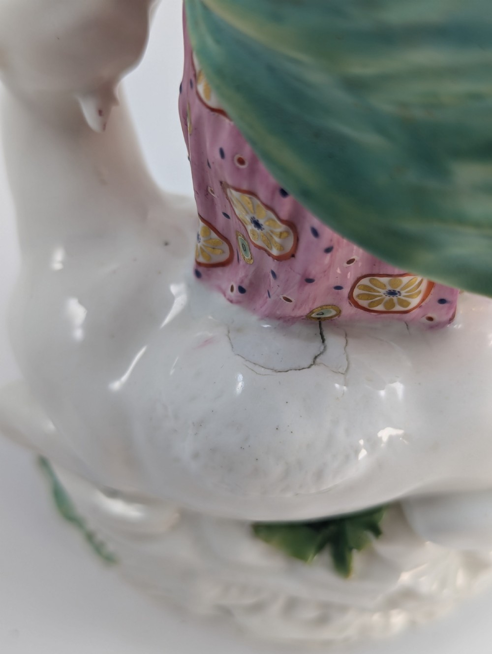 An 18th-century Derby porcelain allegorical figure depicting Asia wearing a floral crown and patterned pink drapery alongside a camel on a scrollwork base. View X