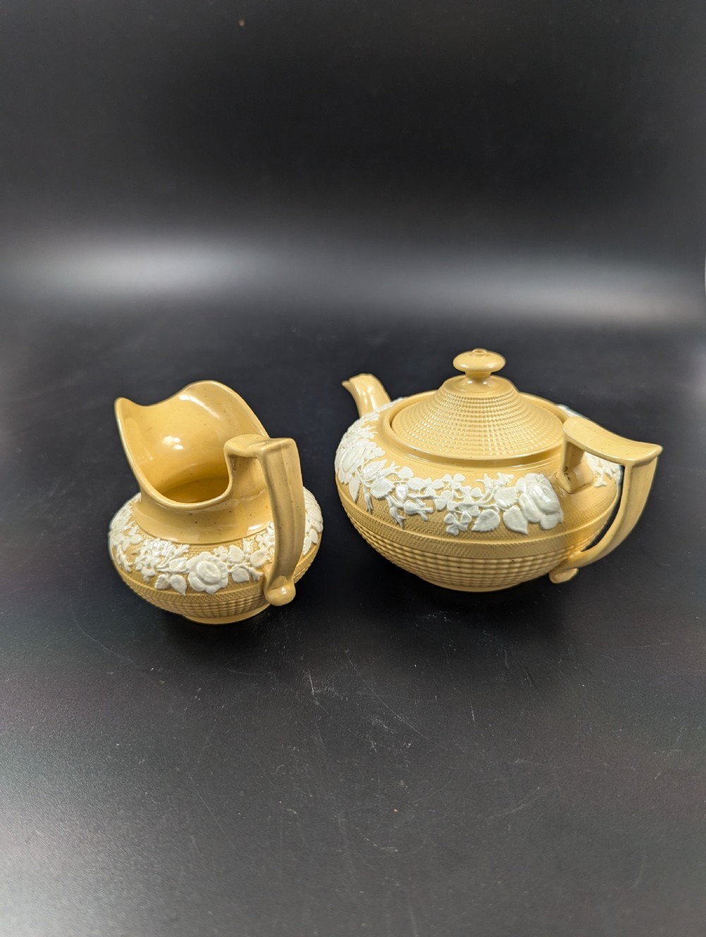 A Regency period buff stoneware teapot and matching creamer jug featuring engine-turned lattice patterning and applied white botanical reliefs. View II